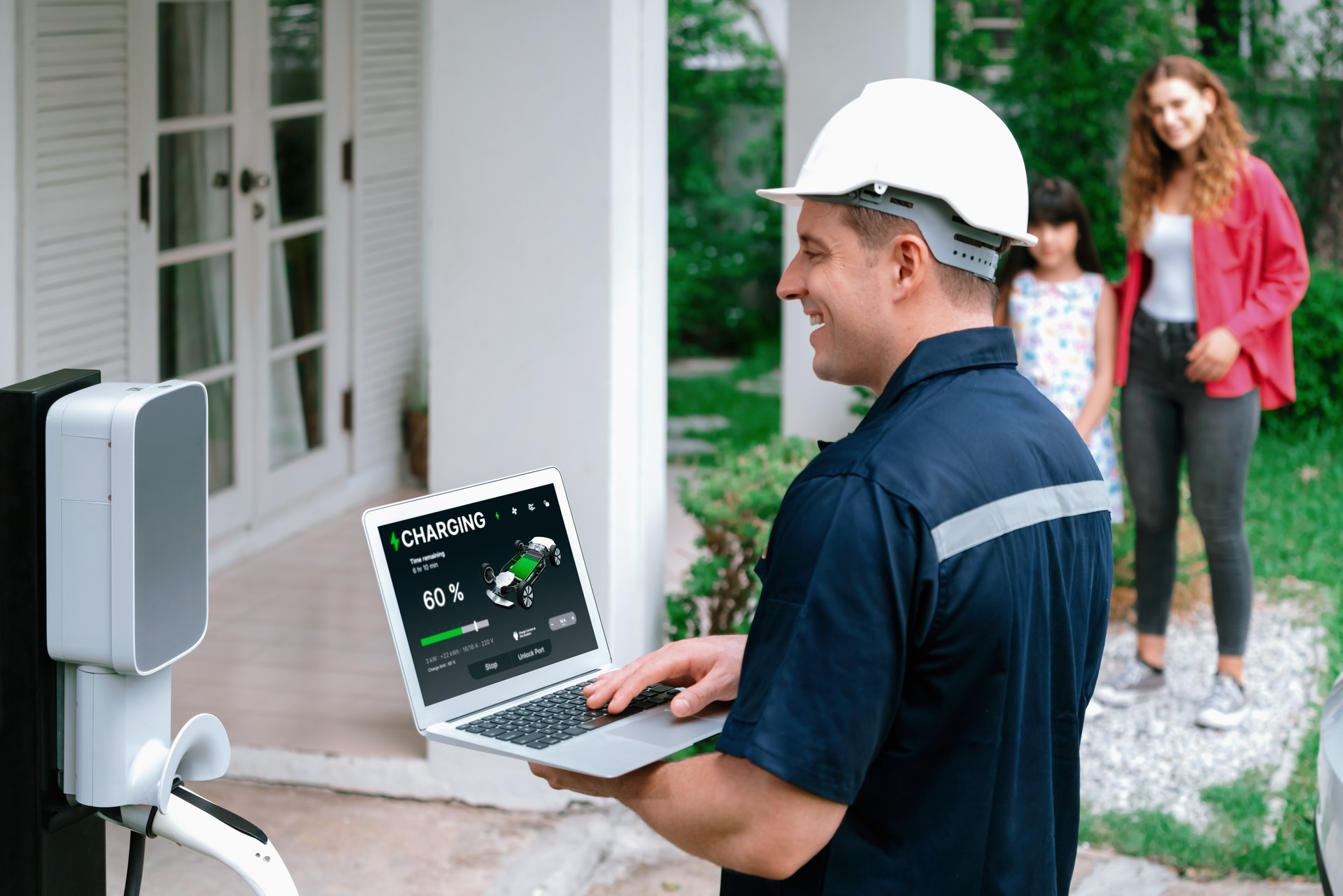 Qualified technician working with laptop for home EV station. Synchronos